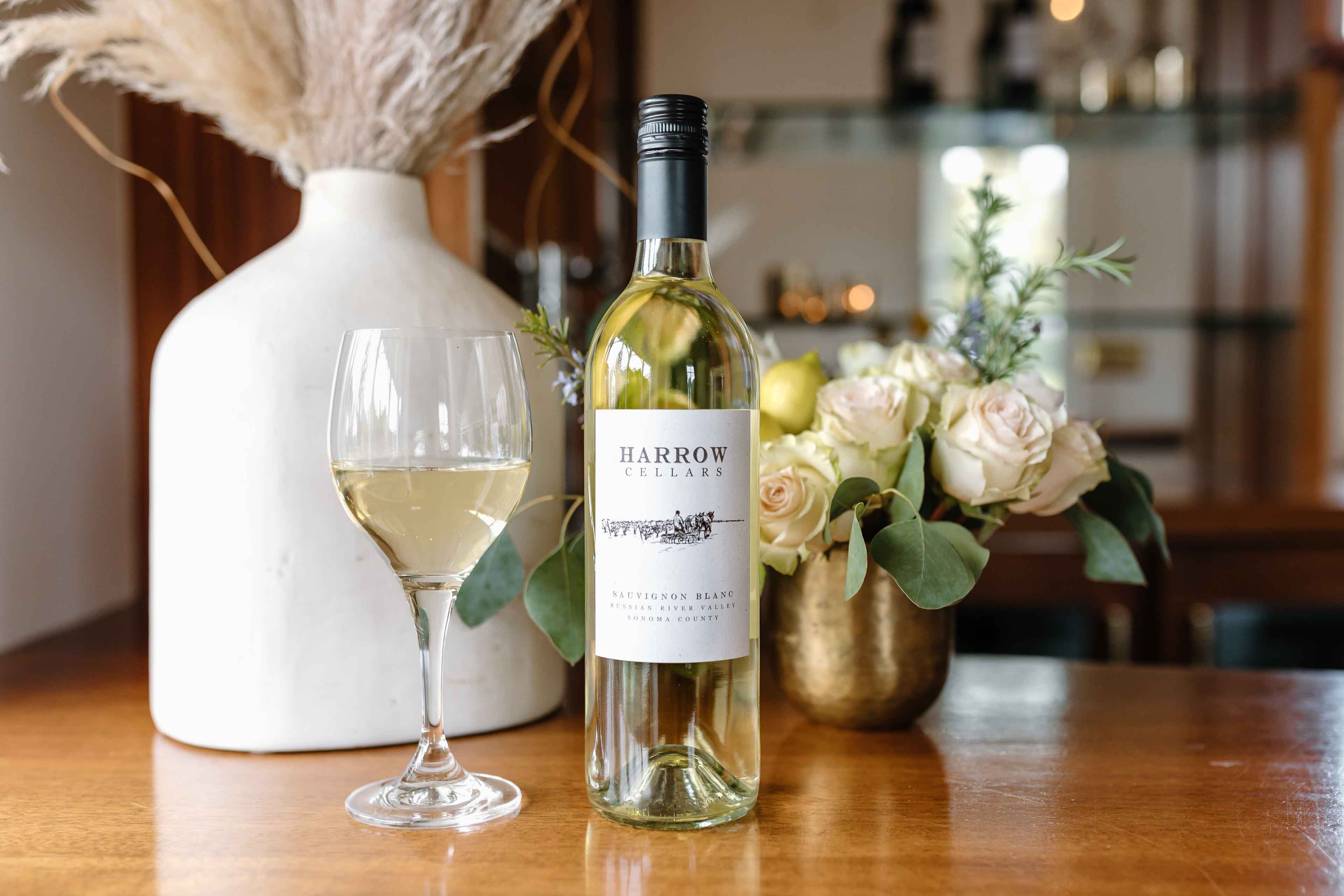 Bottle of Harrow Cellars White Wine On A Bar With Flowers